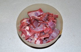 После тщательного промывания подсушиваем мясо бумажным полотенцем, срезаем пленки и нарезаем средними кусочками. Кладем в казан или толстостенную кастрюлю. Смешиваем соевый соус с уксусом, поливаем мясо, посыпаем перцем, перемешиваем.