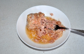 Тушенку выкладываем из банки, убираем жир, мясо с желе разминаем.