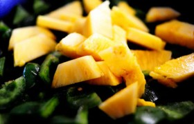 Масло из сковороды сливаем, ставим на тот же огонь, засыпаем сладкий перец, 1 минуту жарим, помешивая, добавляем ананас, а спустя еще минуту - 