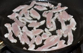 Пока мы это делаем, на самом сильном огне, в большой толстодонной сковороде (если у нас нет сковороды вок)  перекаливаем  налитое в нее масло. И начинаем обжаривать курицу, свободно располагая кусочки для быстрого обжаривания, все время перемешивая, тратя на каждую порцию (мы жарили в 3 приема) примерно 2 минуты. Т.е. мясо должно побелеть и только начинать браться корочкой.