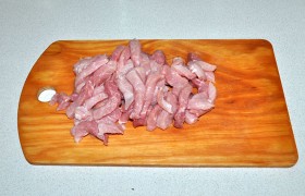 Перед нарезкой мясо споласкиваем и обсушиваем в бумажных полотенцах. Поперек мясных волокон нарезаем ломтики, из них – брусочки по 10-12 мм.