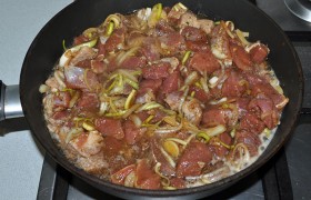 В разогретый сотейник (толстодонную сковороду или кастрюлю) выкладываем мясо с луком и специями, добавляем часть слитого соуса, заливаем кипящую воду из чайника - примерно до половины высоты мяса. Перчим и солим по вкусу, засыпаем дробленый или молотый арахис (если используем его).