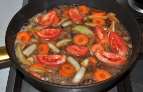 Добавляем дольки помидора. И оставляем мясо  тушиться  на медленном огне до полной мягкости (от часа-полутора до трех). Конечно, под крышкой. 