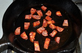 В той же сковороде обжариваем пару минут нарезанную кусочками колбасу чоризо, а вынув ее – 