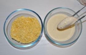 Ставим рядом с плитой миски с кляром и хлопьями. Проверяем масло: оно должно уже  перекалиться . Снижаем огонь примерно до средне-сильного, чтобы крылышки не горели и успевали прожариться. Обмакиваем каждый кусочек в кляр. 