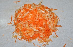 Смешиваем, посыпаем солью и одной ложкой сахара и мнем на столе руками. Овощи дали сок, а объем их стал меньше.