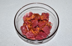 Промытый кусок мяса со всех сторон качественно обсушиваем. Нарезаем средними кусочками-кубиками. Сдабриваем 1 ст. ложкой масла, посыпаем кориандром, перемешиваем.