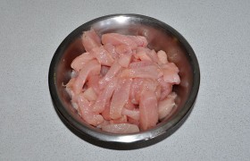 Куриные филе промываем, бумажными полотенцами промокаем всю воду: обсушивание необходимо для правильной жарки. Нарезаем филе поперек на ломтики до 15 мм толщины, ломтики превращаем в дольки той же толщины.