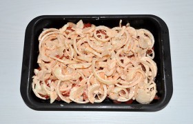 Поставив регулятор духовки на 180-190°, смазываем маслом форму и достаточно плотно выкладываем стейки. Посыпаем  майораном , мускатным орехом. При желании - смазываем майонезом.  Накрываем рыбу слоем помидоров, которые перчим и солим немного, верхний слой – лук.