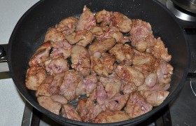 Закладываем в раскаленное масло и, все время помешивая лопаткой и переворачивая, обжариваем 5-7 минут, пока исчезнут капельки крови и кусочки покроются легкой корочкой. Солим и перчим. Накрываем сковороду, выключаем конфорку и оставляем на 4-5 минут.