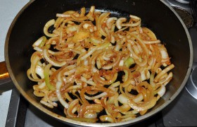 Перекладываем мясо в тарелку, солим, накрываем ее, а в сковороде обжариваем  полукольца лука.