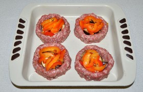 Перекладываем котлеты в форму, промазанную маслом. Заполняем выемки кусочками баклажанов, сладкого перца.
