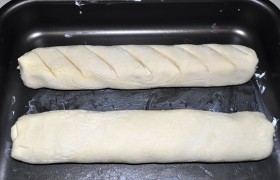Слегка сплющиваем рулеты по всей длине. Для эксперимента на одном из рулетов мы сделали надрезы. Смазываем взбитым (вилкой) яйцом или только желтком.