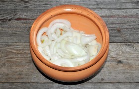 В горшок укладываем нарезанный широкими полукольцами лук.