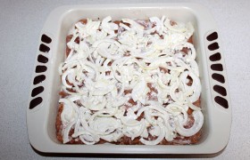 Засыпаем мясо слоем лука со сметаной.