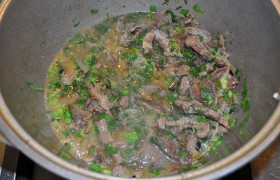Добавляем к мясу подсушенную и порубленную зелень, солим и перчим, снова накрываем и тушение продолжается еще 25-30 минут. Если требуется – подливаем немного воды.