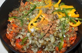 подсыпаем их в сковороду с сердечками. Вот теперь можно посолить блюдо и поперчить, посыпать  сушеной  или свежей зеленью, дать закипеть, накрыть – и на малом огне оставить тушиться еще на 15-20 минут.
