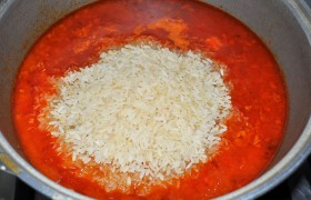 Засыпаем рис, добавляем обе головки чеснока (неочищенного), перемешиваем. Жидкости должно быть примерно на 3-4 см выше риса. 
Ставим на самый маленький огонь и готовим еще час. 
