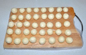 Ставим блюдечко с растительное маслом для смачивания ладошек. Для шариков укрываем доску пленкой, слегка смазываем ее маслом. Отщипывая маленькие порции, формуем из теста мелкие шарики, примерно 22-24 мм. У нас получилось 40 шариков.