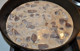 Приправляем мясо солью, перцем, посыпаем приправой, вливаем сметану, добавляем горячую воду – соус должен почти прикрыть мясо. После закипания накрываем, снижаем огонь до малого и тушим говядину до готовности-мягкости. 