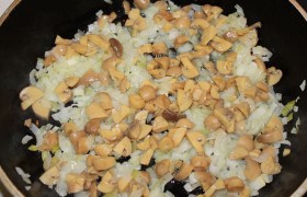 Шинкуем луковицу, кладем в разогретую средним огнем конфорки сковороду с растительным маслом (1-2 ст. ложки), где лук томится 6-8 минут. Добавляем нарезанные грибы, увеличиваем огонь до средне-сильного, помешивая, ждем, пока выпарится жидкость и немного поджарится лук.