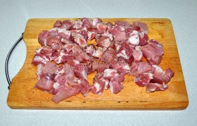Свиное мясо промываем, после чего качественно подсушиваем со всех сторон бумажным полотенцем. Делим поперек волокон на ломти примерно 2-сантиметровой толщины, из которых нарезаем кубики. Посыпаем перцем, лучше свежемолотым.