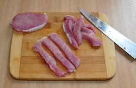 Поступаем, как при готовке обычных отбивных: промытое мясо обсушиваем в бумажных полотенцах. Точно поперек волокон разрезаем на ломти 12-15 мм толщины. И слегка, в пакетике,  отбиваем  с обеих сторон. Отделяем жир и нарезаем полоски-палочки шириной 15-20 мм.