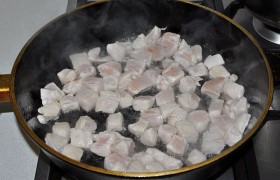 Перед жаркой раскаляем на сильном огне сковороду с 2-3 ст. ложками  масла. Когда  масло перекалилось , выкладываем индейку. Обжариваем 2-3 минуты, перемешивая лопаткой. За это время мясо успевает приготовиться и становится очень светлым. Убираем его из сковороды. 