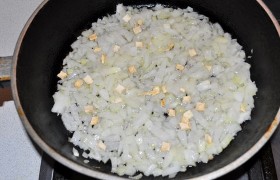 Лук шинкуем мелко и на маленьком огне обжариваем в растительном масле до легкого золотистого цвета и мягкости, 10-12 минут. Добавляем корень петрушки.