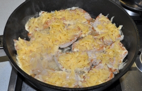 Снижаем огонь под сковородой, посыпаем мясо крупно тертым сыром, накрываем плотной крышкой и недолго держим мясо на конфорке – только до расплавления сыра.