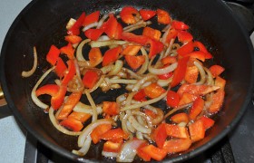 Вынув мясо, снижаем огонь конфорки до среднего,  пассеруем  лук 5 минут, добавляем сладкий перец, помешивая, держим на огне еще 4-5 минут. 
