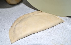 Закрыть чебурек можно разными способами. Либо хорошо придавить-склеить довольно широкие края и обрезать фигурным ножом. Либо защипать край знакомой  «веревочкой» . Мы воспользовались третьим: примяли соединенные края и, перекатывая с нажимом край тарелки, расположенной под углом к тесту, просто отрезали его.