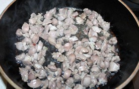 Включив сильный огонь конфорки, раскаляем  топленое  масло и жарим желудочки, постоянно вороша-поворачивая, 2-4 минуты. Как только все кусочки посветлели – убираем огонь на средний, тушим от 10 до 15 минут, чтобы желудочки немного помягчели.
