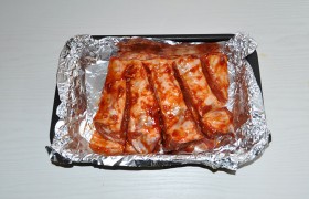Хорошо вымешиваем компоненты маринада (чеснок пропускаем через пресс). Чтобы не терять ни капли маринада, сразу подготавливаем форму с фольгой. Обмазываем маринадом со всех сторон, в том числе и в разрезах, кладем в форму, остатки маринада – наверх. Накрываем и оставляем на столе на 1-2 часа. Или в холодильник – на несколько часов.