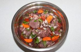 Говядину маринуем за 5-7 часов до приготовления. Мясо нарезаем 30-35-миллиметровыми кубиками. В миску складываем  нарезанные : помидоры, морковь, чеснок, лук, зелень петрушки и укроп, перец, добавляем говядину и заливаем вином. Накрыв, ставим на нижнюю полку холодильника.