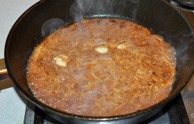 Сложив мясо на тарелку, кладем в сковороду очищенные,  раздавленные  плоскостью ножа чесночинки, через 30 секунд вливаем из миски маринад, 
