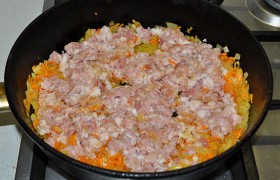 Кладем мясной фарш и разминаем, не давая образоваться комочкам. Солим и перчим.