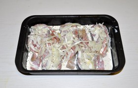 Раскладываем тонко нарезанный лук, поливаем сливками.