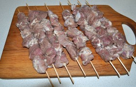 Когда духовка разогрелась до 250°, нанизываем мясо на шпажки и укладываем на решетку, не забыв смазать ее растительным маслом. Ниже ставим противень с пергаментом – пусть капли падают сюда, а не на дно духовки, где отмывать их потом – та ещё работа.