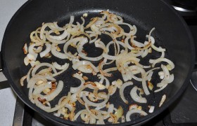 Очищенный лук шинкуем тонкими полукольцами. На среднем огне  пассеруем  в растительном масле до золотистого цвета.