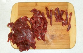 Острым ножом, нарезая поперек волокон ломти мяса и слегка отбив их, превращаем вырезку в соломку не более 0,5-0,8 см толщиной, посыпаем перцем.  А на сковороде у нас тем временем обжариваются на среднем огне полукольца лука до золотистого цвета.