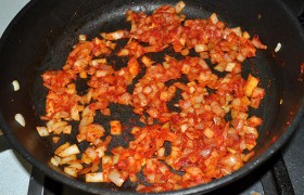 Пожарив и остаток мяса, освобождаем сковороду и засыпаем порубленные средним кубиком луковицы, снизив огонь до среднего, пассеруем лук 7-9 минут, добавляем томатную пасту и сахар, посыпаем перцем и паприкой.