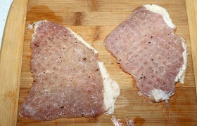 Промытое и обсушенное мясо нарезаем – поперек волокон, конечно – на ровные ломти толщиной до 15-18 мм.  Отбиваем  обе стороны деревянным молотком до 8-9 мм, не забыв поместить в пакетик во избежание брызг и лучшего качества отбивания. Если тонкий слой сала стягивает отбивную – надрезаем его – обычно достаточно в одном месте. Обе стороны посыпаем перцем из мельнички и солим. 