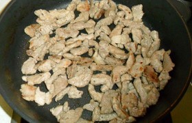Поставив сковороду с маслом на сильный огонь, сначала это  масло перекаливаем , в него закладываем мясо и, все время помешивая, 3-4 минуты обжариваем до легких корочек. Если мясо было замороженным и дает много жидкости – лучше слить в миску большую ее часть. Если оно не помещается в один ряд на сковороде – жарим в два приема. 