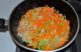 Нашинкованные лук и сельдерей, натертую морковь кладем в хорошо разогретое на среднем огне растительное масло,  пассеруем , порой помешивая, 12-13 минут. И еще 2-3 минуты даем заправке покипеть, залив 1-2 поварешки бульона и поперчив на свой вкус. 