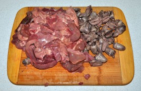 Тем временем до чистой воды промываем куриную печень, срезаем все лишнее, нарезаем печёнку нетолстыми дольками. Отваренные сердечки делим пополам вдоль.