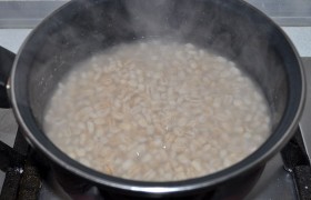 Мясо кладем в 3-литровую кастрюлю с холодной водой. После закипания добавляем одну луковицу, корень петрушки и перец горошком. На слабом огне мясо  сварится  по всем правилам через час-полтора. Сразу же (отдельно) варим и перловку – этот процесс занимает, в зависимости от сорта и возраста крупы, от 50 до 90 минут. Но при желании ее можно варить вместе с мясом. 