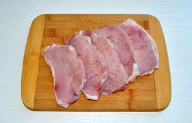Порядок подготовки мяса у нас привычный для отбивных: мясо мы промываем, сложенными бумажными полотенцами тщательно снимаем влагу, нарезаем на 5-6 пластов (не забудем – поперек волокон). И, закладывая в пакетик из пищевой пленки,  отбивае м обе стороны, надрезав слой сала, если он стягивает отбивную. 
