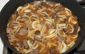 Заливаем горячей водой – она не должна покрывать мясо. И кладем один и другой перец. Плотно накрываем крышкой, увидев, что вода закипела – переводим огонь на тот, что обеспечивает почти незаметное кипение. И оставляем на 1,5-2,5 часа. Время зависит от качества говядины, которая должна тушиться, пока не станет мягкой.