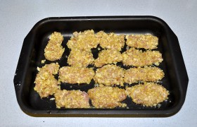 Форму промазываем маслом. Кусочки филе обваливаем в муке, в яйцах и крошках чипсов и раскладываем в форме.